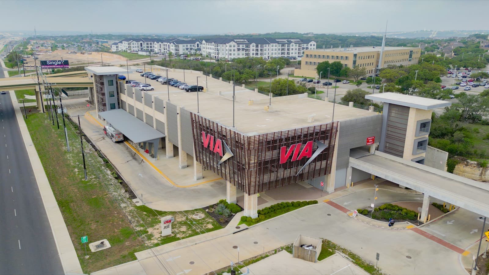 Transit hub with a large red sign beside a highway